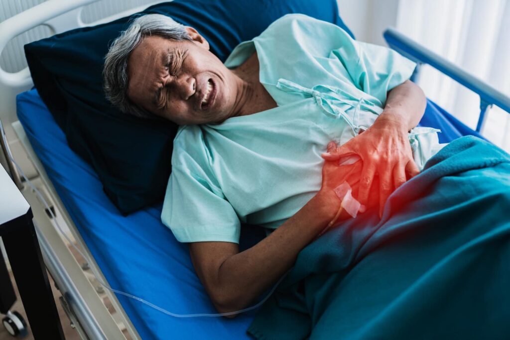 A man writhing in pain in a hospital