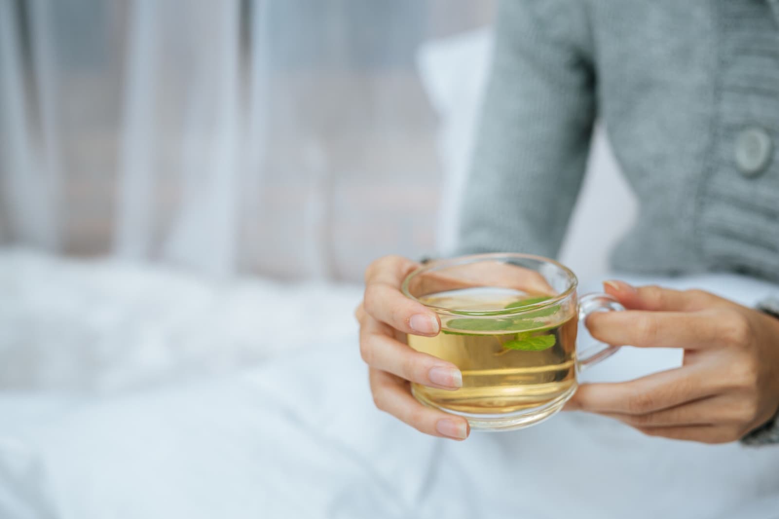 Female hands holding a cup of green tea