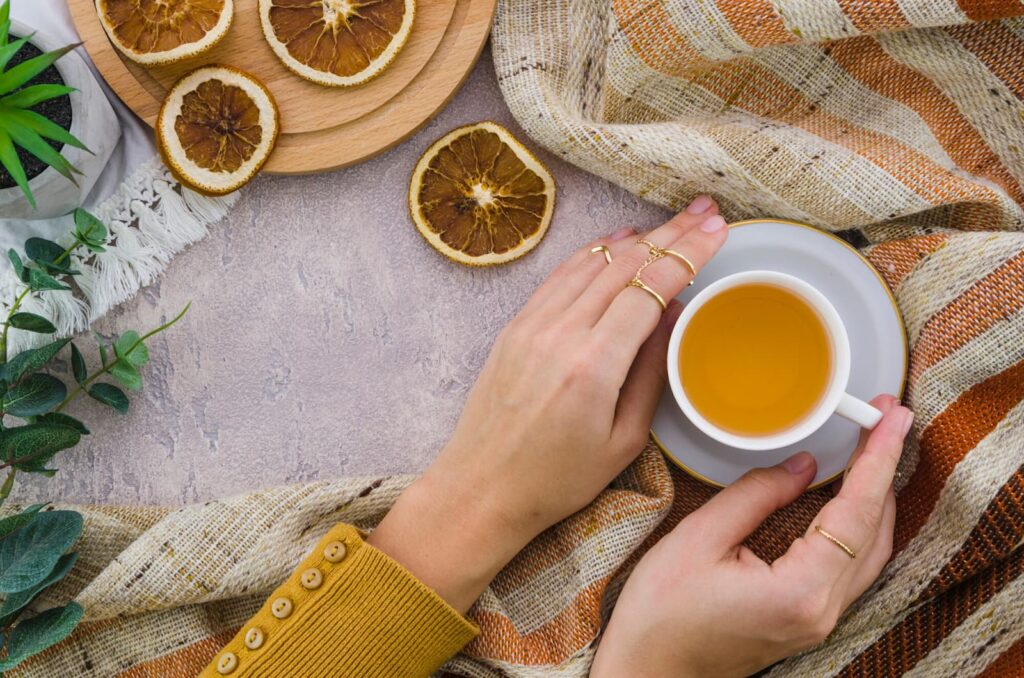 Top view of woman's hand holding a cup of herbal tea